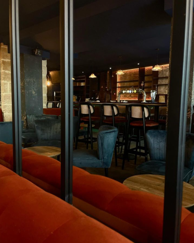 Vue intérieure du bar Oculto rénové par Diso design à Paris, mettant en avant un espace chaleureux avec des meubles confortables et des lumières tamisées.